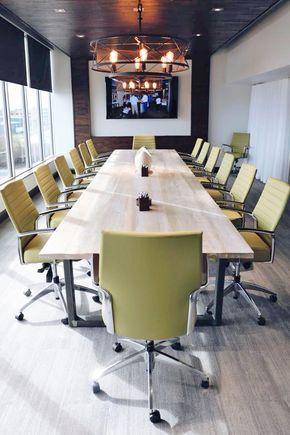 an empty conference room with yellow chairs and a flat screen tv mounted to the wall