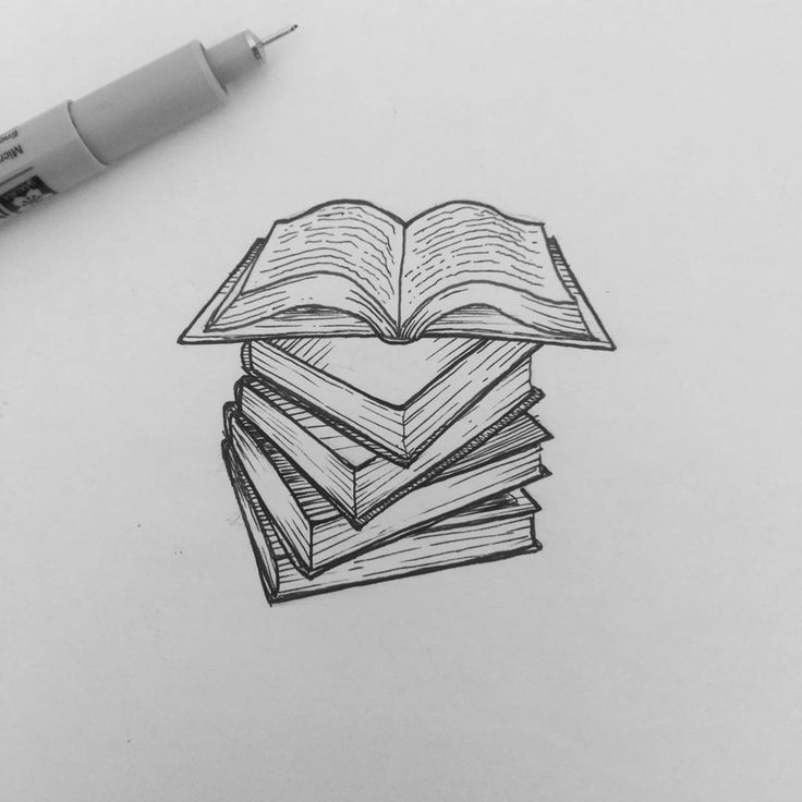 a stack of books sitting on top of a white paper next to a marker pen