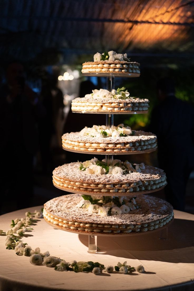 three tiered cake stand with cookies and flowers on it