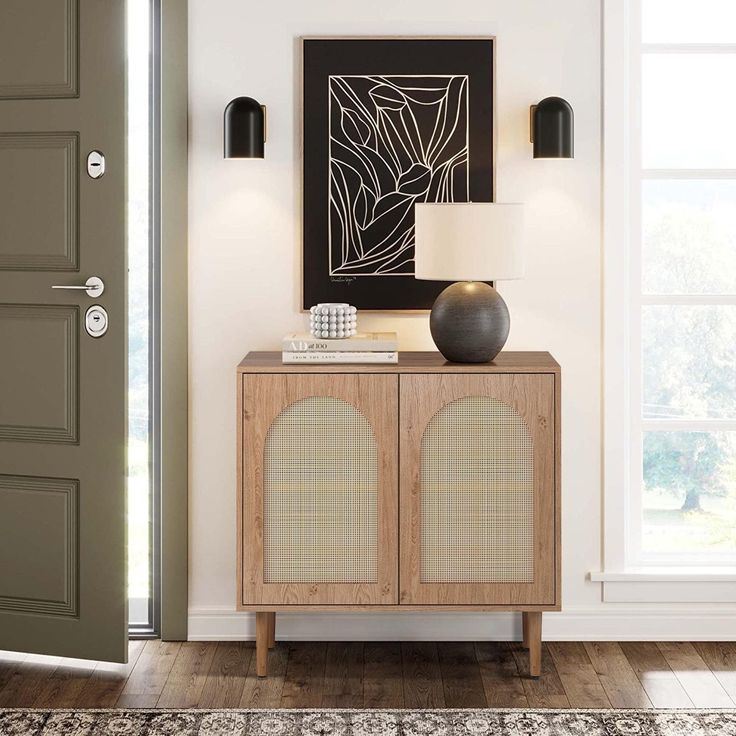 a living room with a door and a lamp on the sideboard in front of it