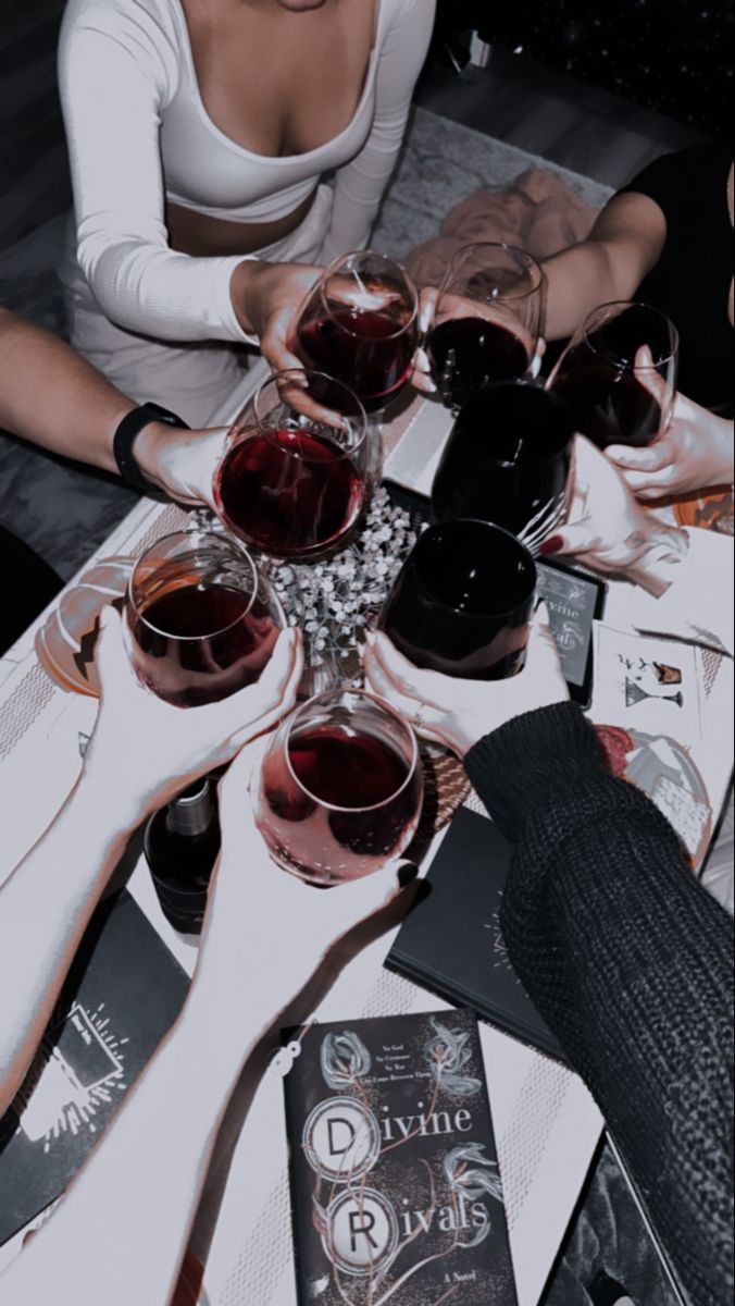 a group of people sitting around a table with wine glasses on top of each other