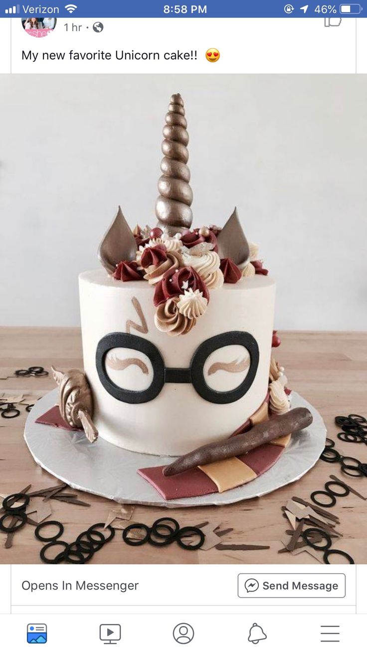 a birthday cake decorated like a unicorn with glasses and horn on top, sitting on a table