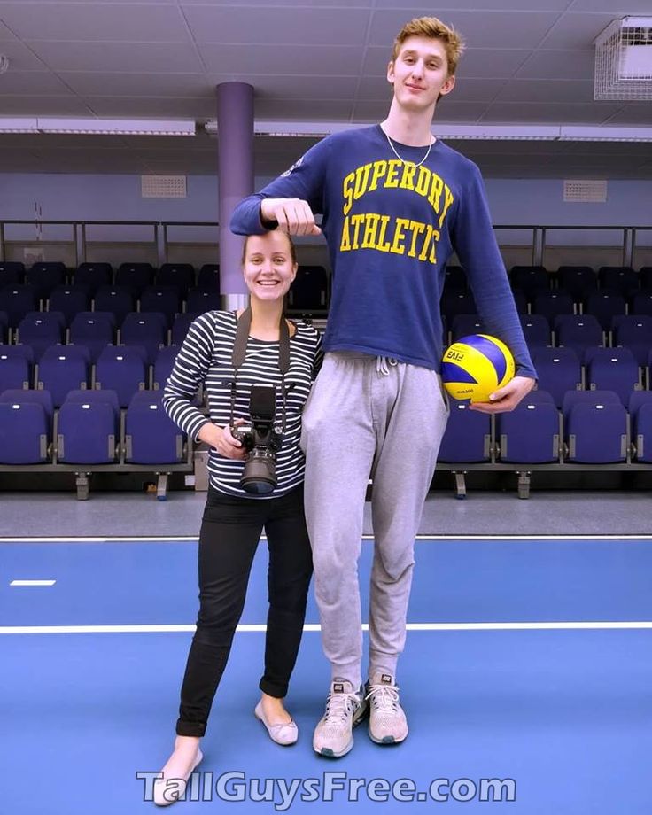 two people standing on a court with a ball in their hands and one person holding a camera