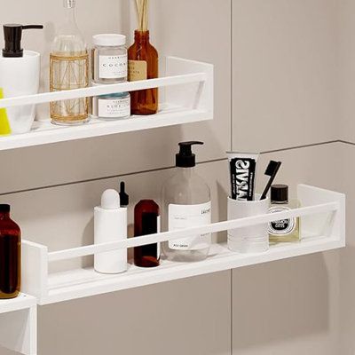 two white shelves filled with different types of bathroom items