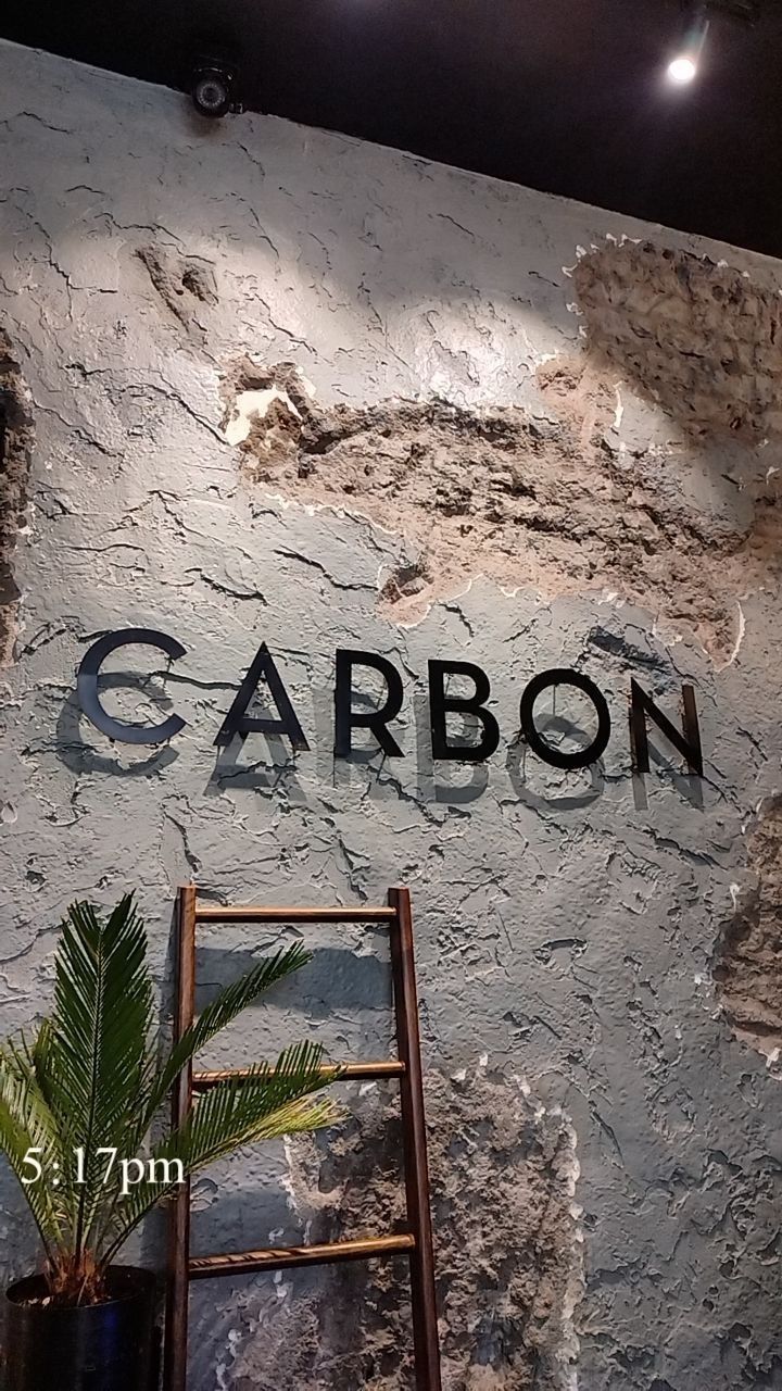 the sign for garbon is next to a ladder with a potted plant on it