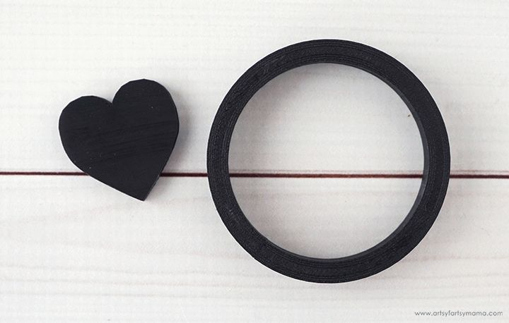 a black rubber ring next to a wooden heart