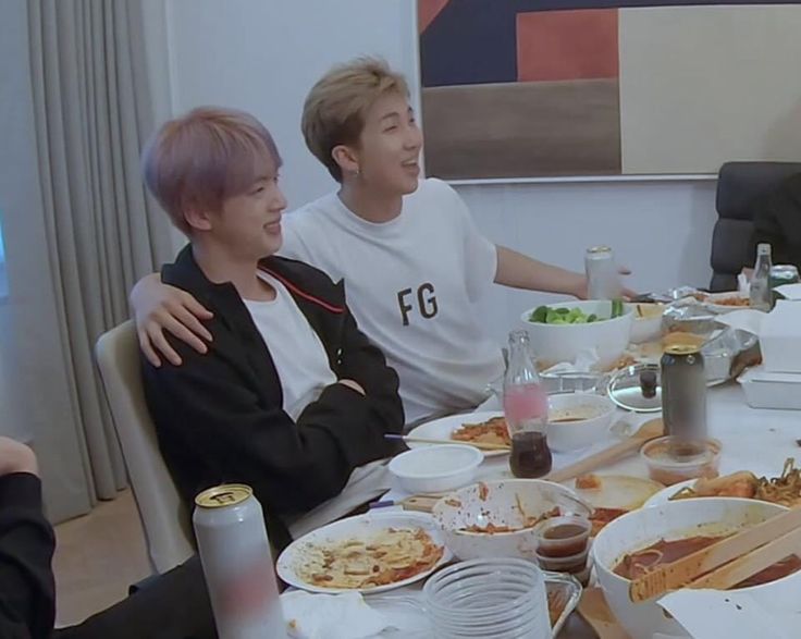 two men sitting at a table with plates of food