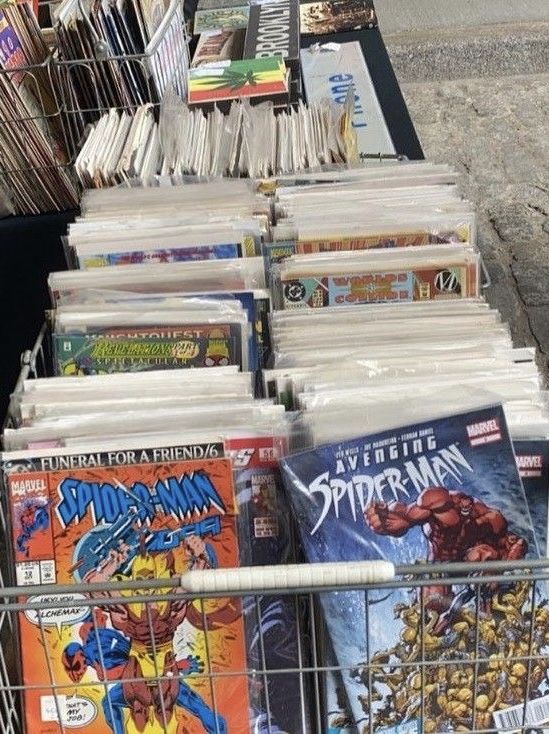 a shopping cart filled with comic books next to a sidewalk