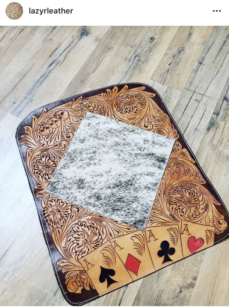 a wooden table topped with playing cards on top of a hard wood floor next to a white rug