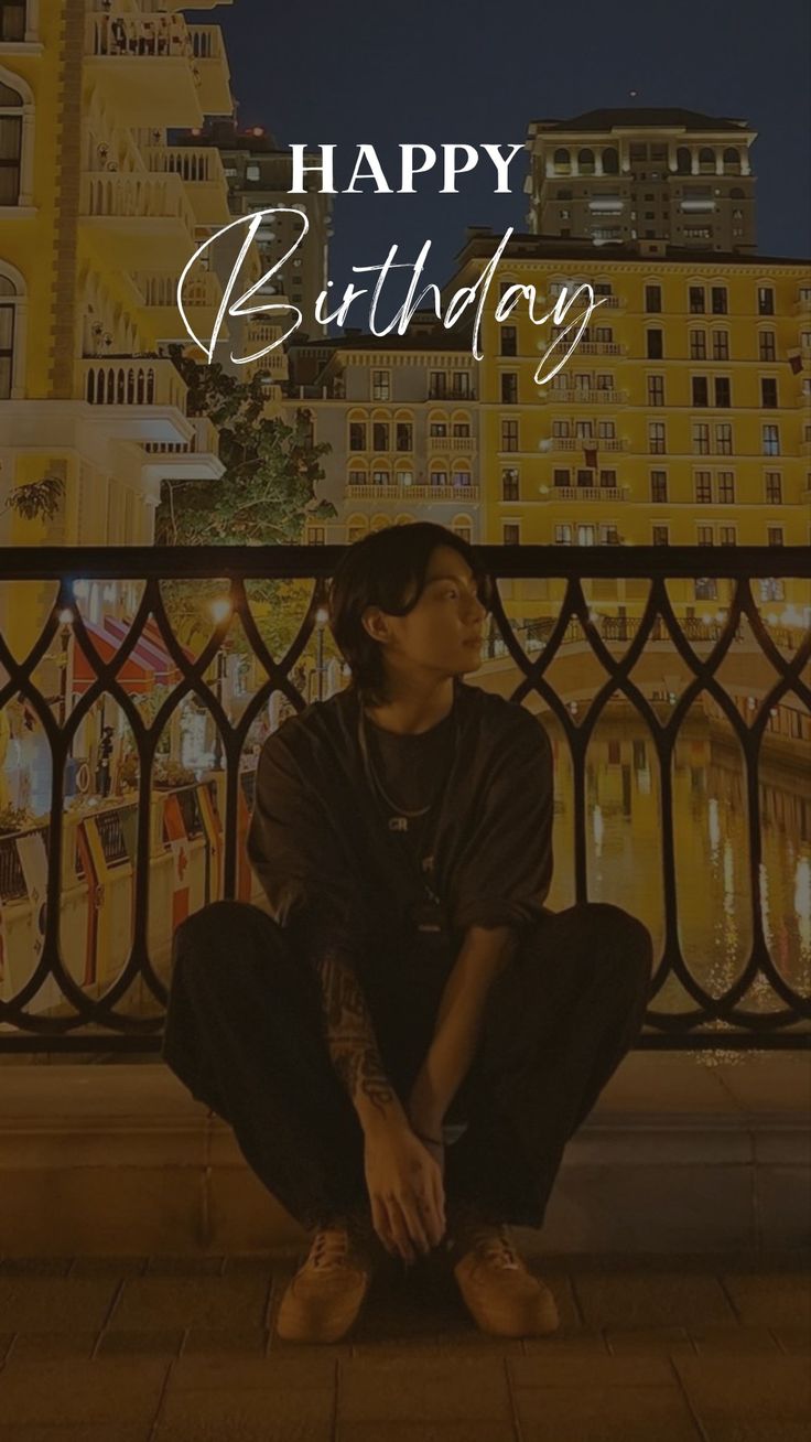 a young man sitting on top of a balcony next to a building with the words happy birthday