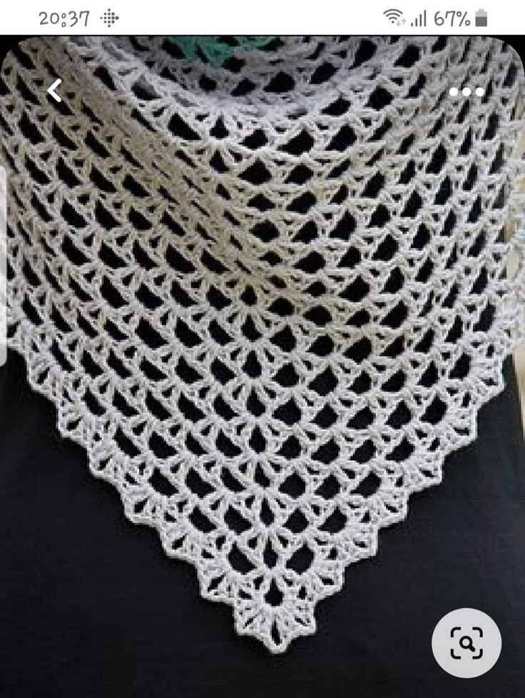 a woman wearing a white crochet shawl