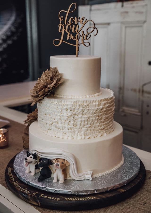 a wedding cake with two dogs on top