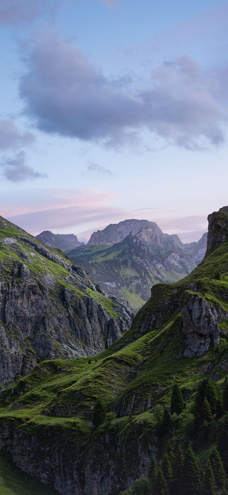 the mountains are covered in green grass