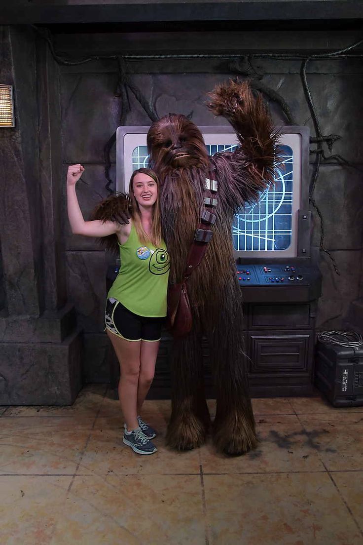 a woman standing next to a star wars character