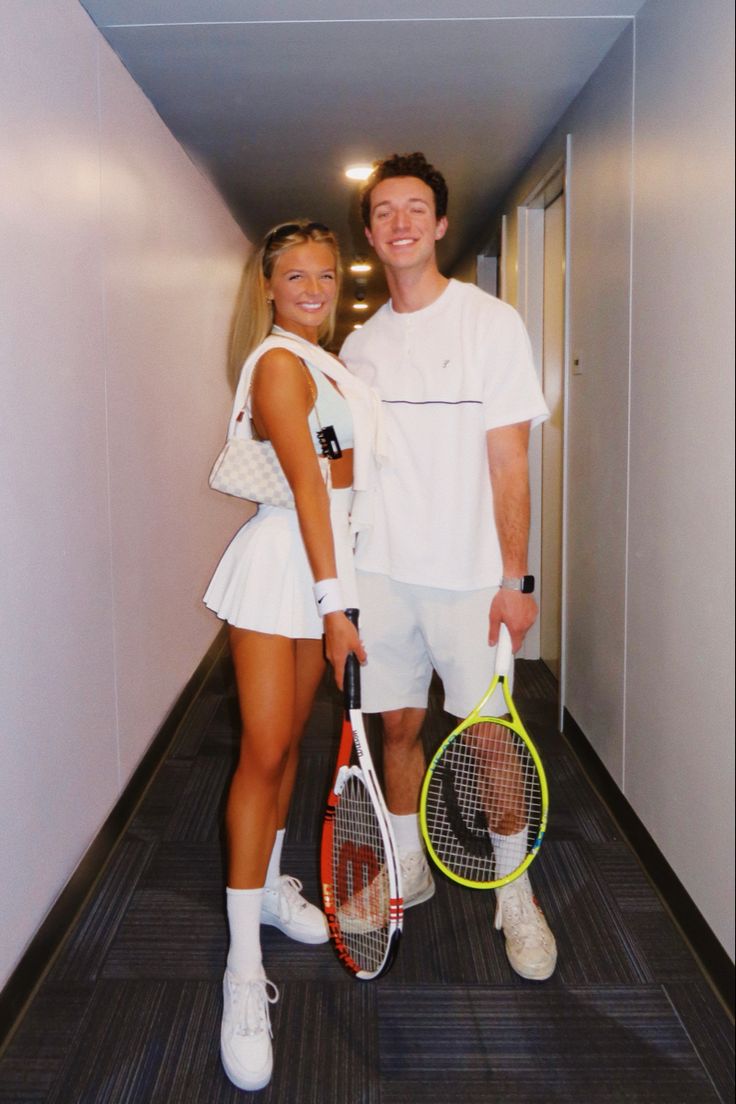 a man and woman standing next to each other holding tennis racquets