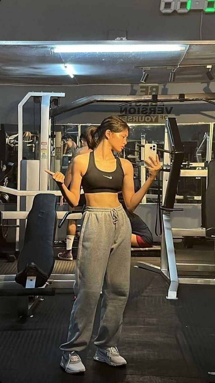 a woman standing in the middle of a gym