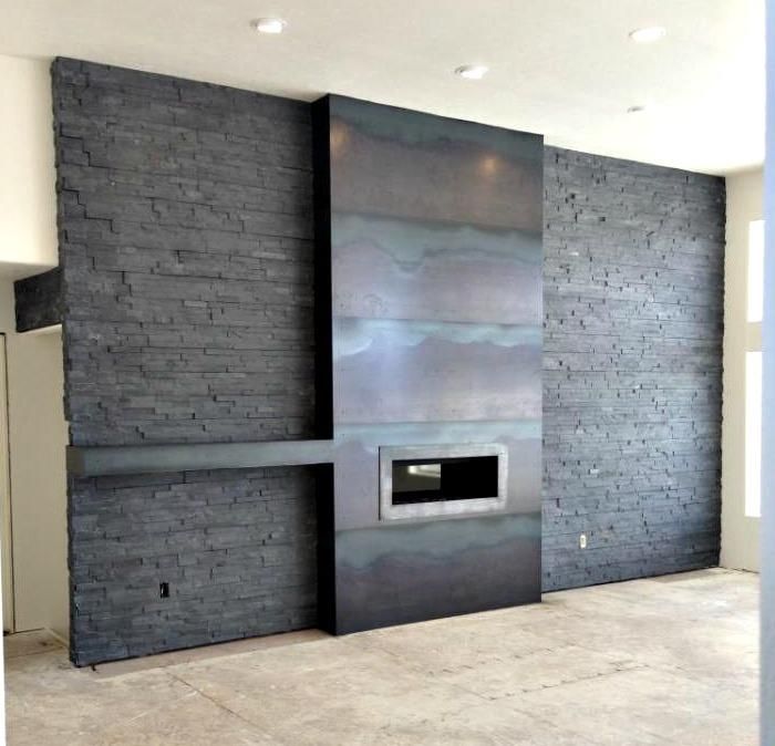 an empty room with a brick wall and fireplace in the center, surrounded by concrete blocks