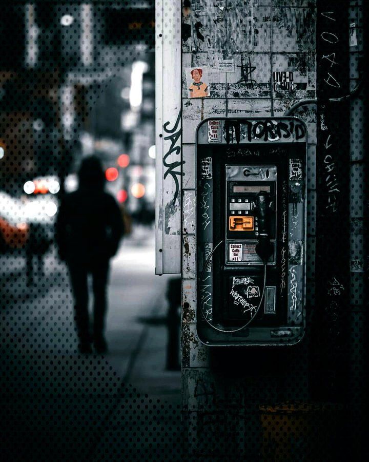 a person walking down a sidewalk next to a parking meter covered in grafitti