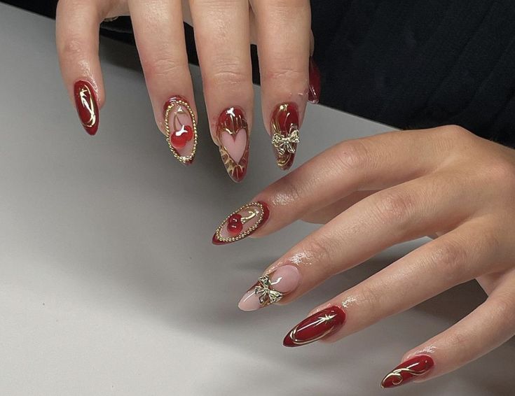 a woman's hands with red and gold manies on their nails, holding onto a white table