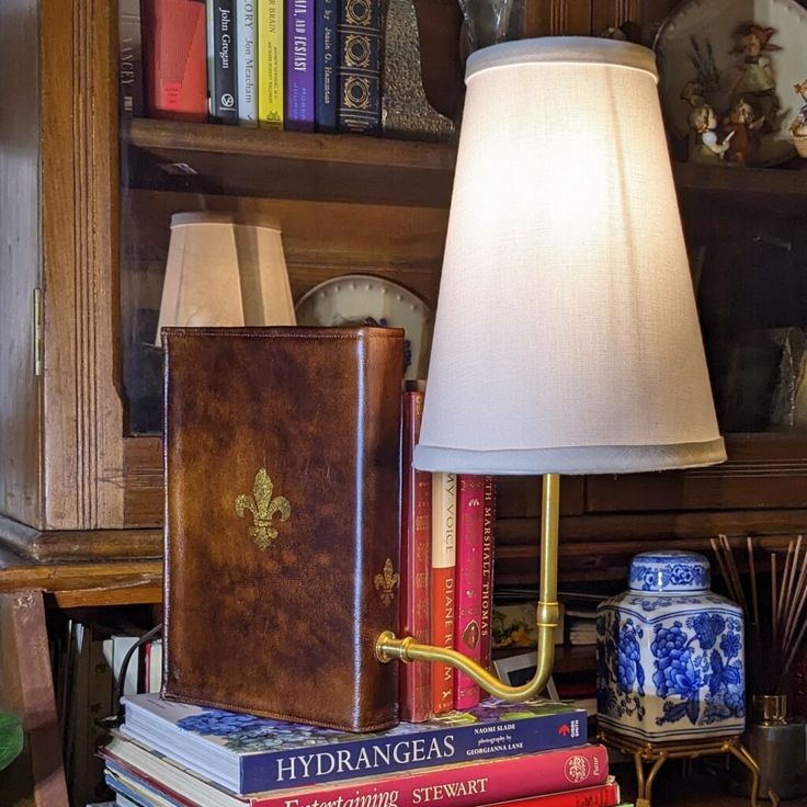 a lamp sitting on top of a table next to books