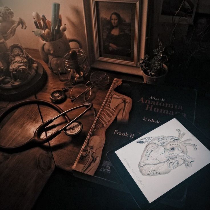 a table topped with books and glasses on top of a wooden table next to a framed photo