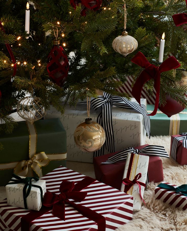 presents under the christmas tree with candles and ornaments