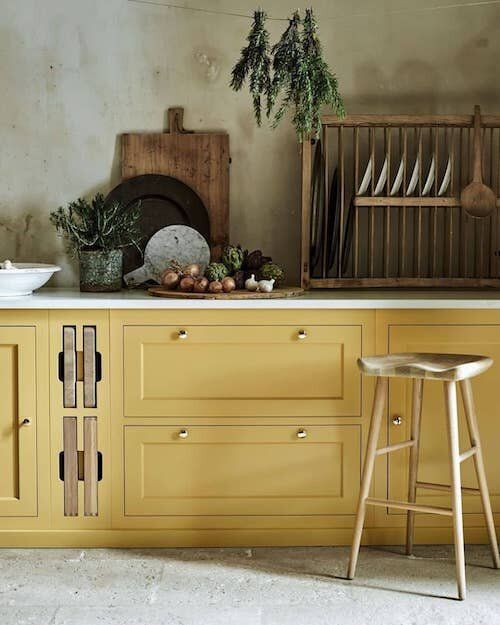 a kitchen with yellow cabinets and white counter tops