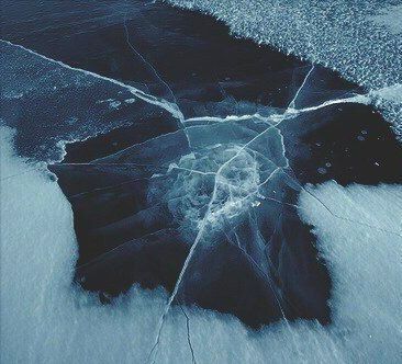 an abstract photograph of water and ice on the ground, with lines drawn across it