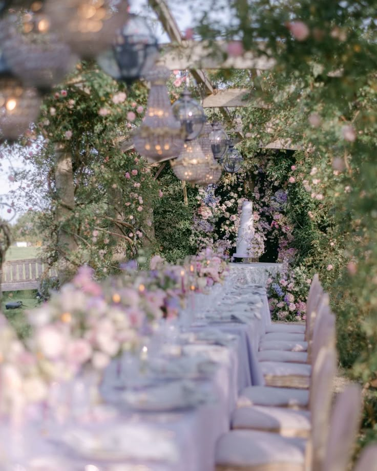 an outdoor dining area with tables and chairs set up for a formal function in the garden