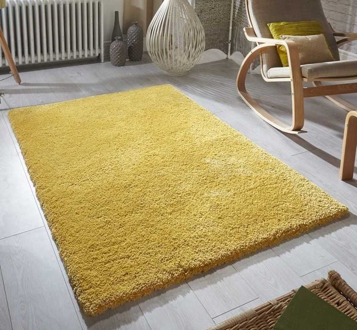 a living room with yellow rugs and chairs in it, along with a radiator