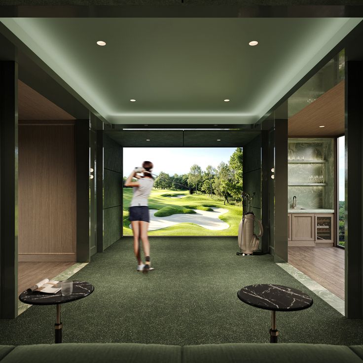 a woman is playing golf in a room with green carpet and two tables on either side