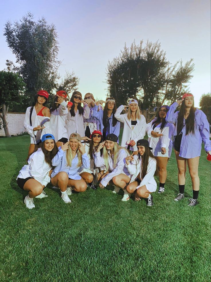 a group of young women standing on top of a lush green field next to each other