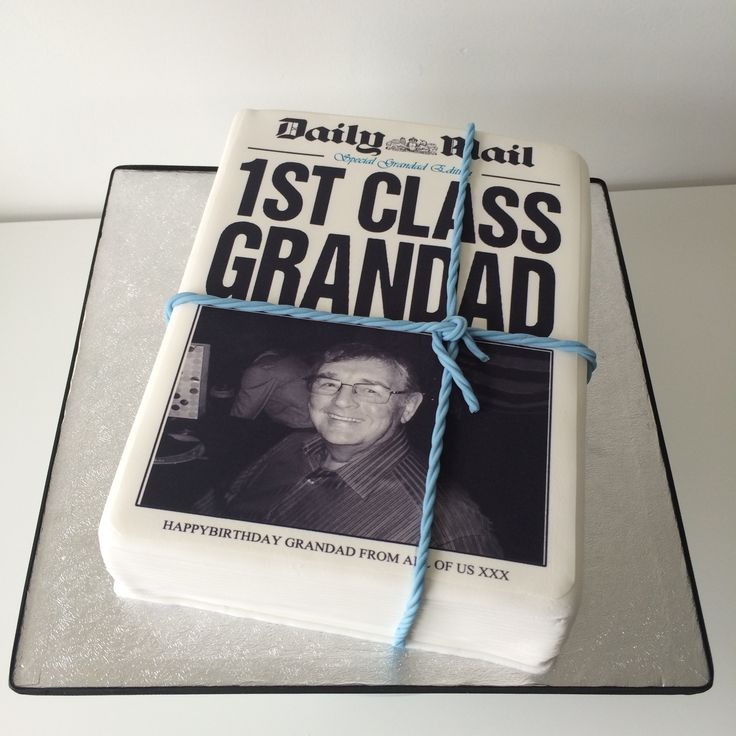 a cake with a book on top of it that says 1st class grandad and tied in blue string