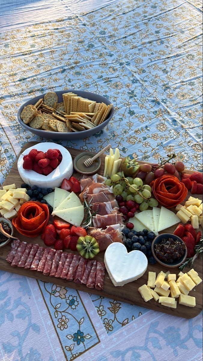 a platter with cheese, crackers and fruit