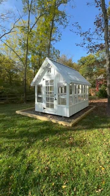 a small white house sitting in the middle of a field