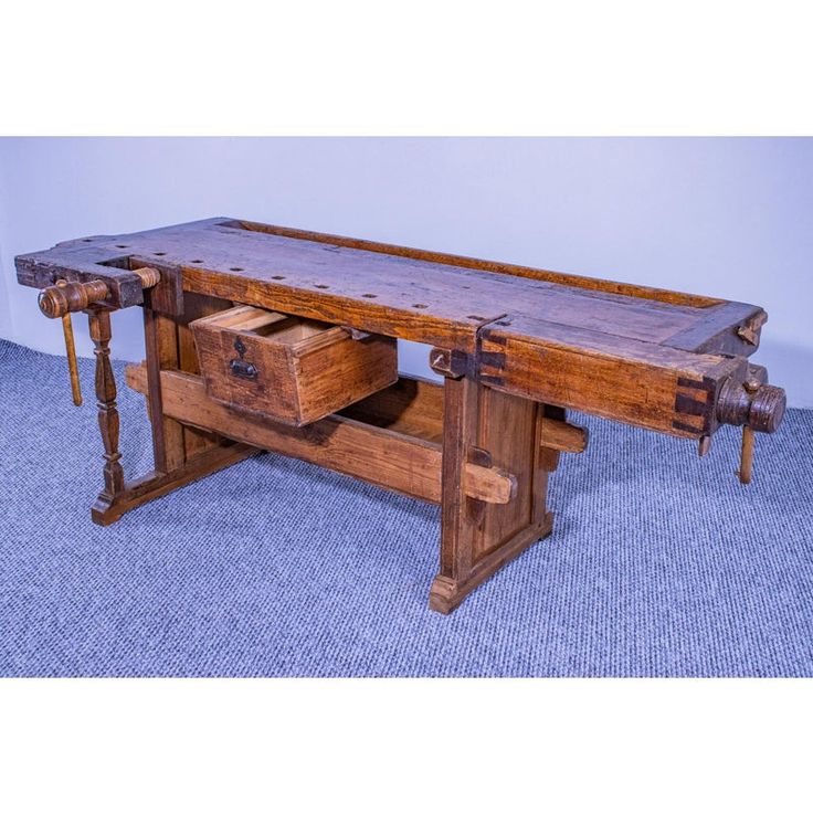 an old wooden work bench with drawers on the bottom and two wheels attached to it