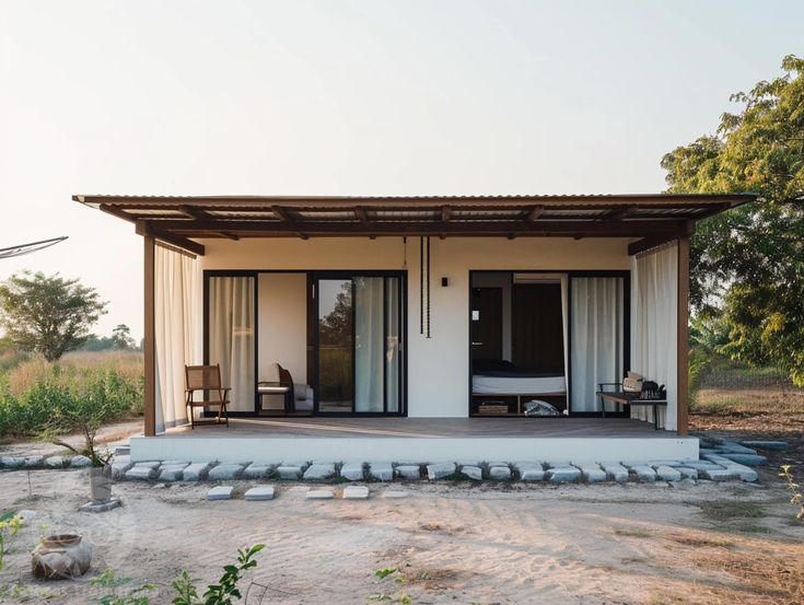 a small white house sitting on top of a dirt field