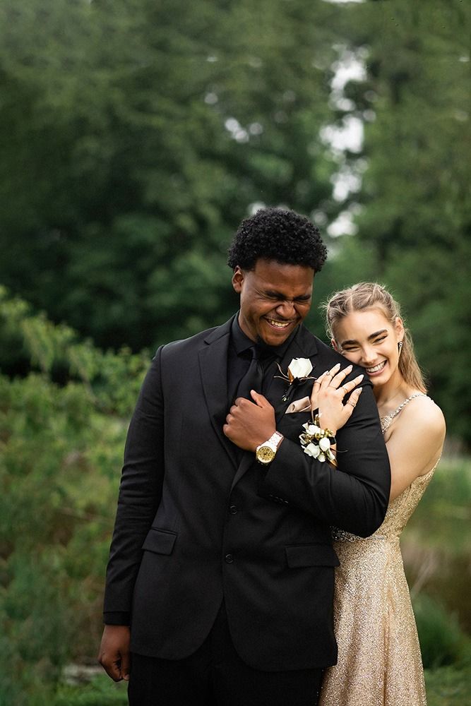 a man in a suit and woman in a gold dress posing for a photo together