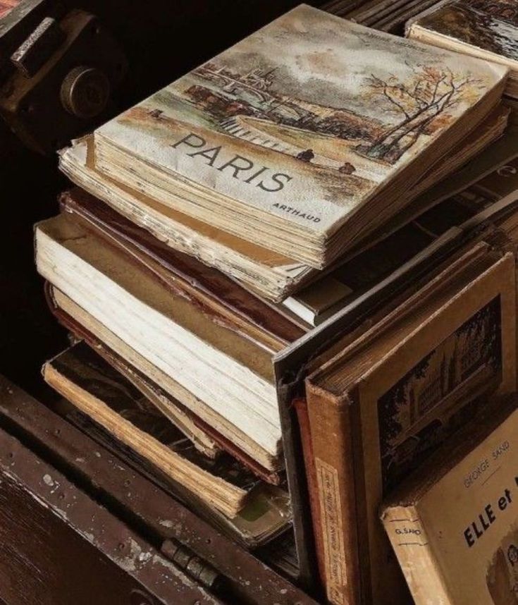 several books stacked on top of each other in an old trunk with the lid open