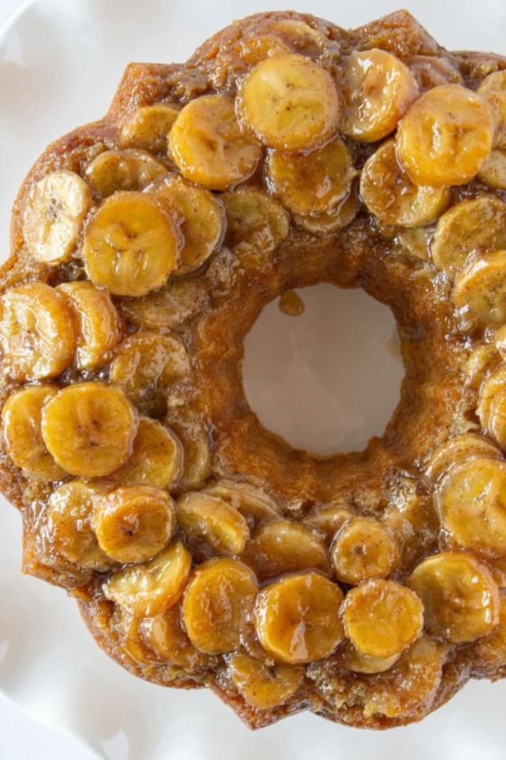 a cake with bananas on it sitting on top of a white tablecloth covered plate