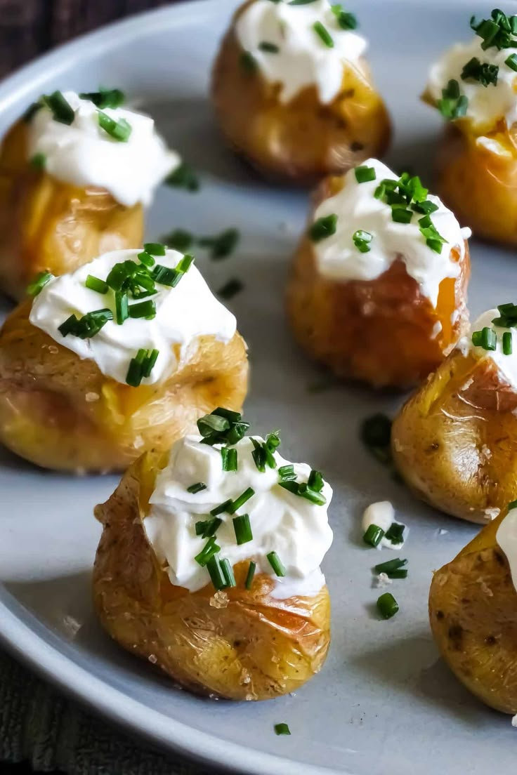 small potatoes topped with sour cream and chives on a plate