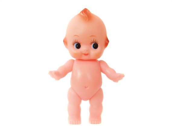 a pink baby doll with blue eyes and an orange bib on it's body