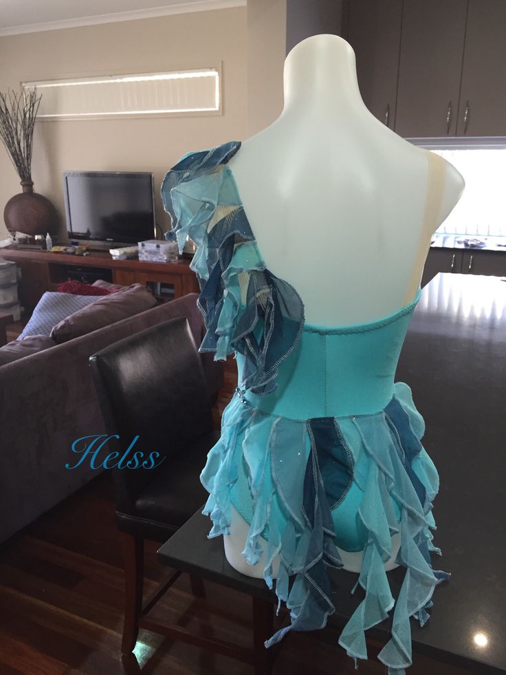 a mannequin with blue ruffles on it's back in a living room