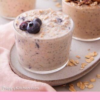 two cups filled with oatmeal and blueberries on top of a plate