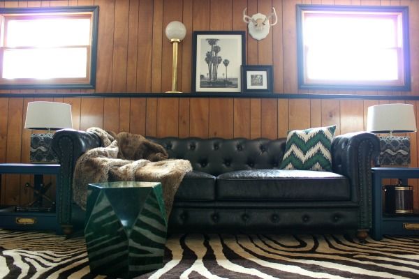 a living room with zebra print rug and black leather couch