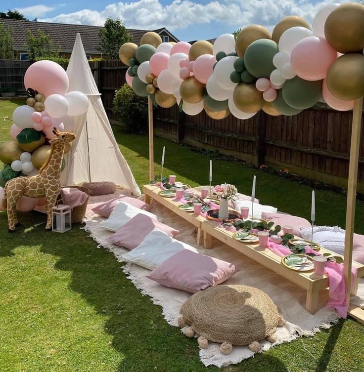 a table set up for a baby shower with pink and gold balloons