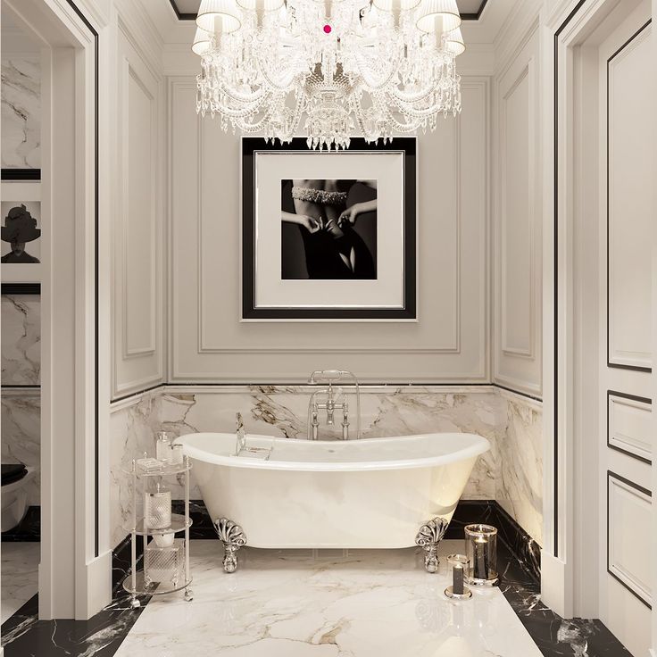 a white bath tub sitting in a bathroom next to a chandelier above it