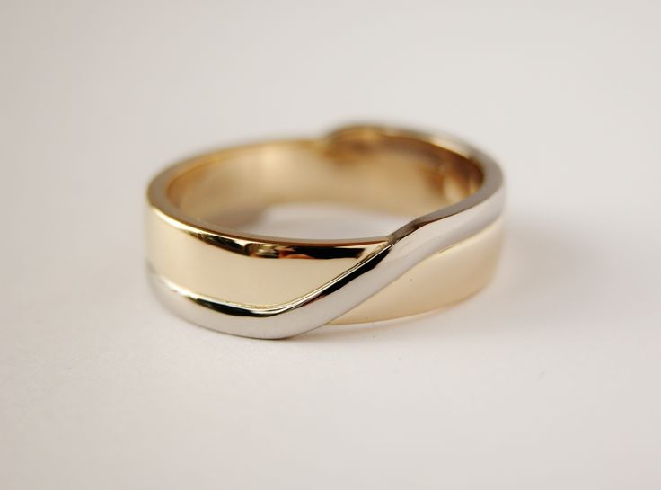 a close up of a gold ring on a white surface