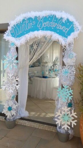 an arch decorated with snowflakes and frosting for a winter wonderland birthday party