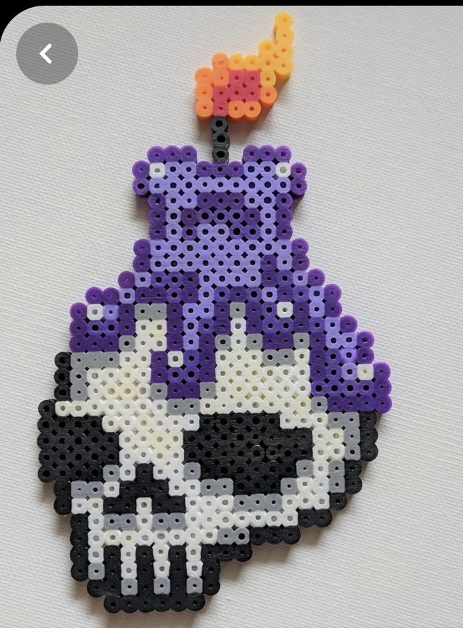 a beaded ornament with an image of a skull wearing a purple hat